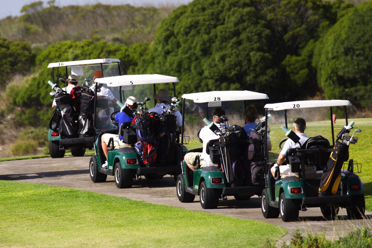 Golfer teeing off at Bali National Golf Club with ocean view background